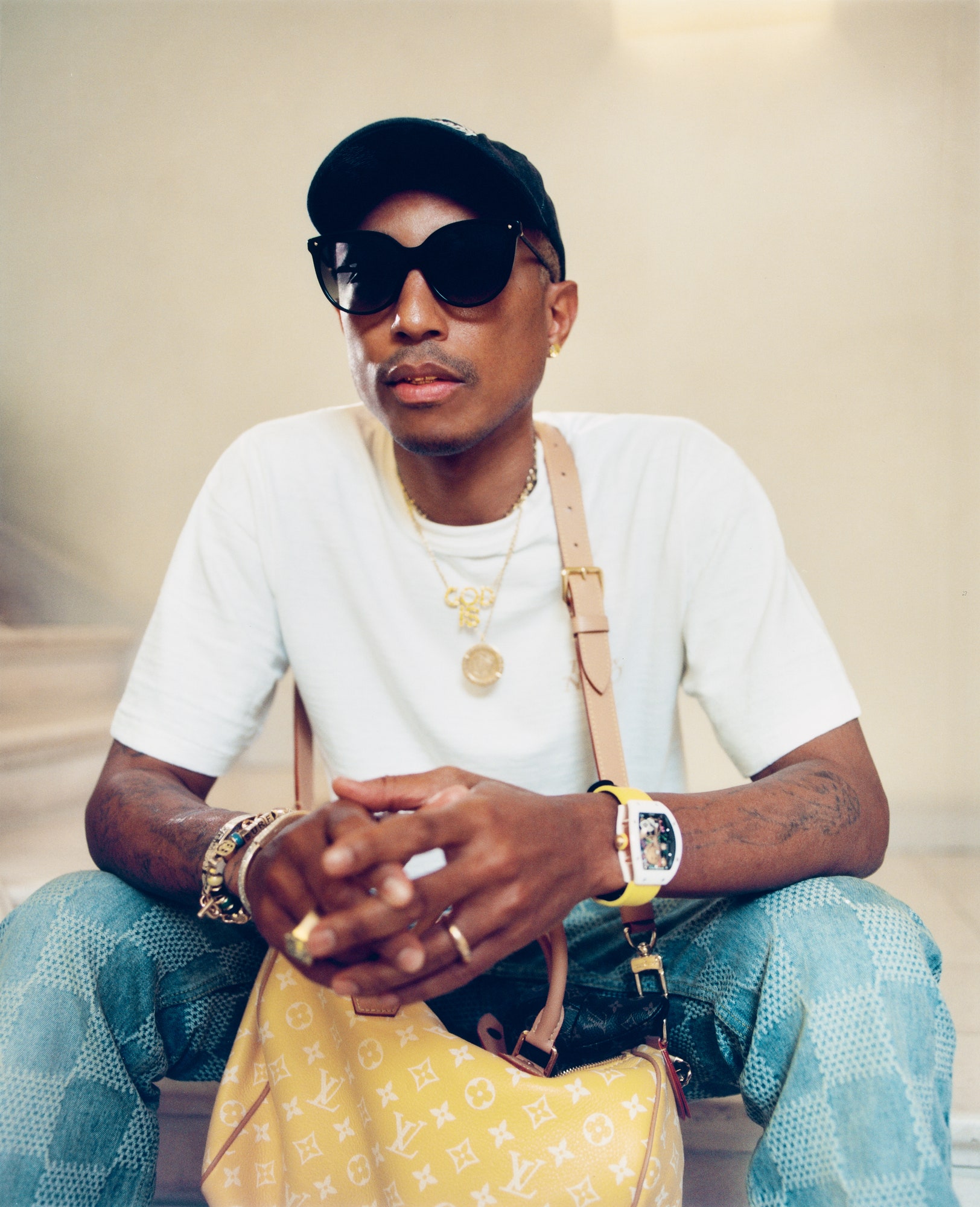 Image may contain Pharrell Williams Person Sitting Accessories Jewelry Necklace Ring Adult Glasses and Sunglasses